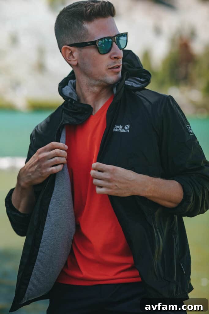 Close-up of a person demonstrating how a lightweight Jack Wolfskin jacket folds into its integrated stuff sack, highlighting the compact design of the Pack and Go collection.