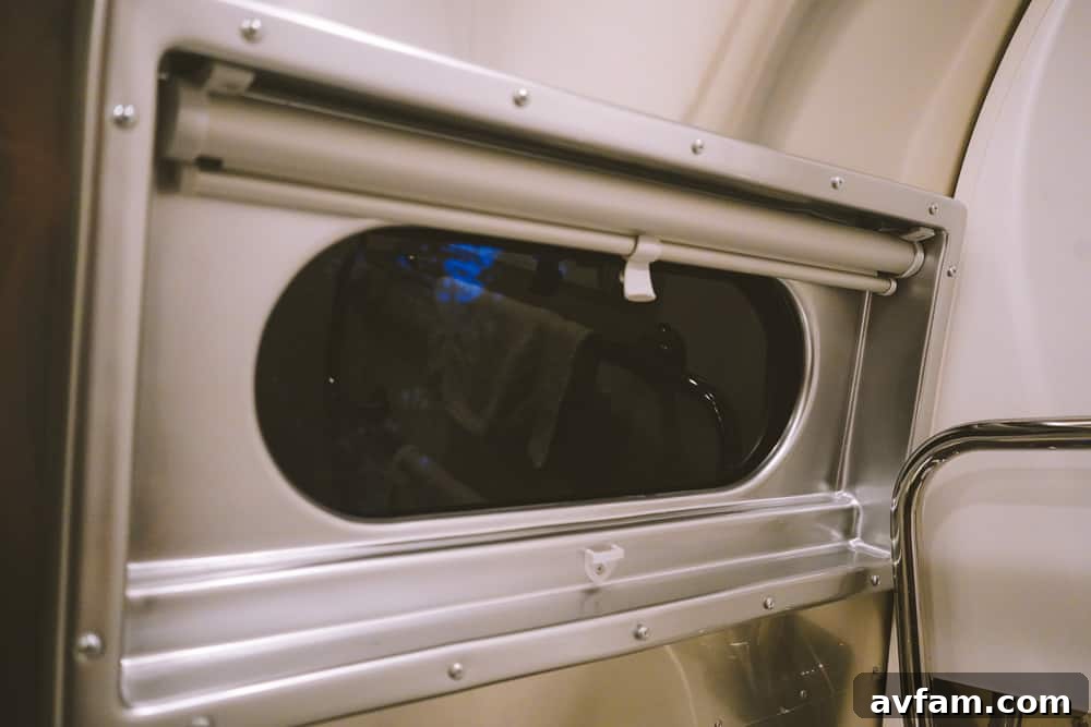 A spacious living area within an Airstream, featuring a sofa and ample light.