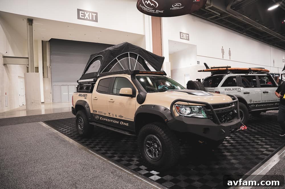 A custom overland rig, fully equipped with rooftop tent, auxiliary lighting, and recovery gear for adventure.