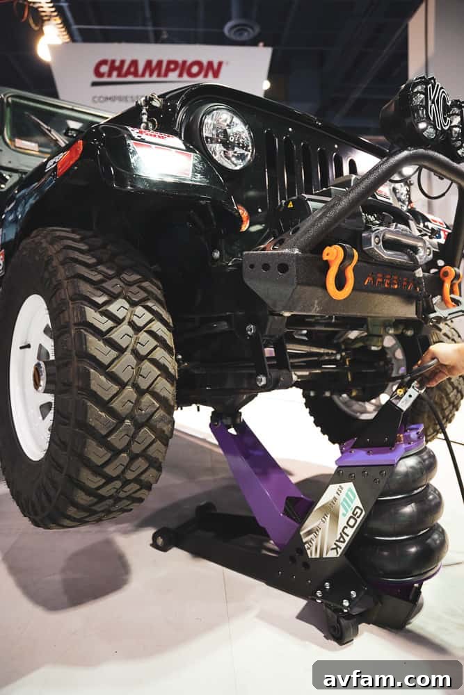 An extreme custom off-road truck build, featuring massive tires and a powerful stance, dominating the SEMA floor.