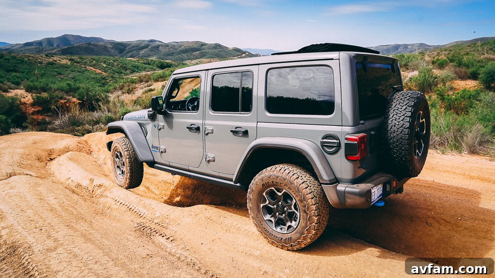 Jeep Wrangler 4XE Silent Trailblazer 3 Close-up of the front of a Jeep Wrangler 4XE parked on a dirt trail.
