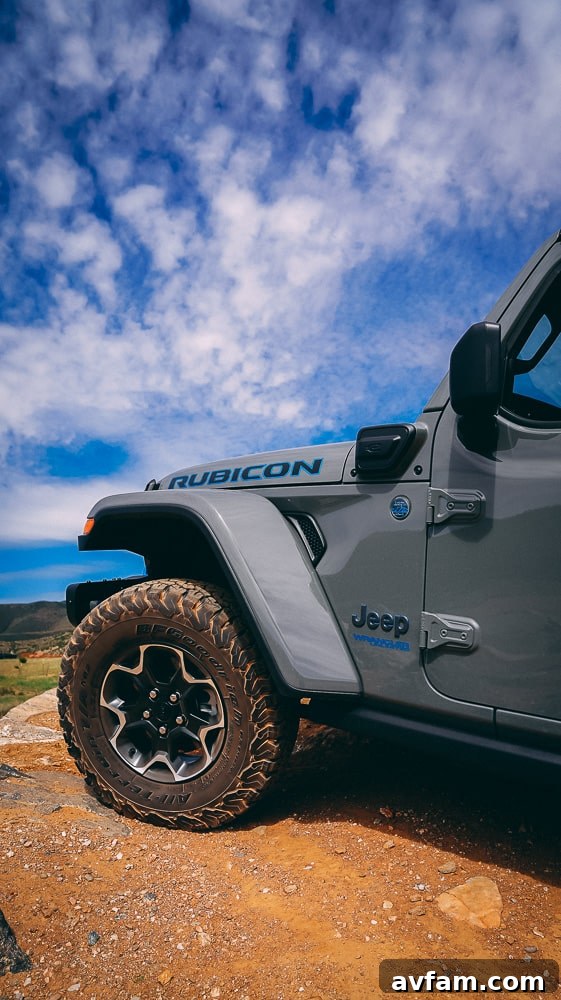 Jeep Wrangler 4XE Silent Trailblazer 29 A vibrant blue Jeep Wrangler 4XE standing tall against a mountain backdrop.