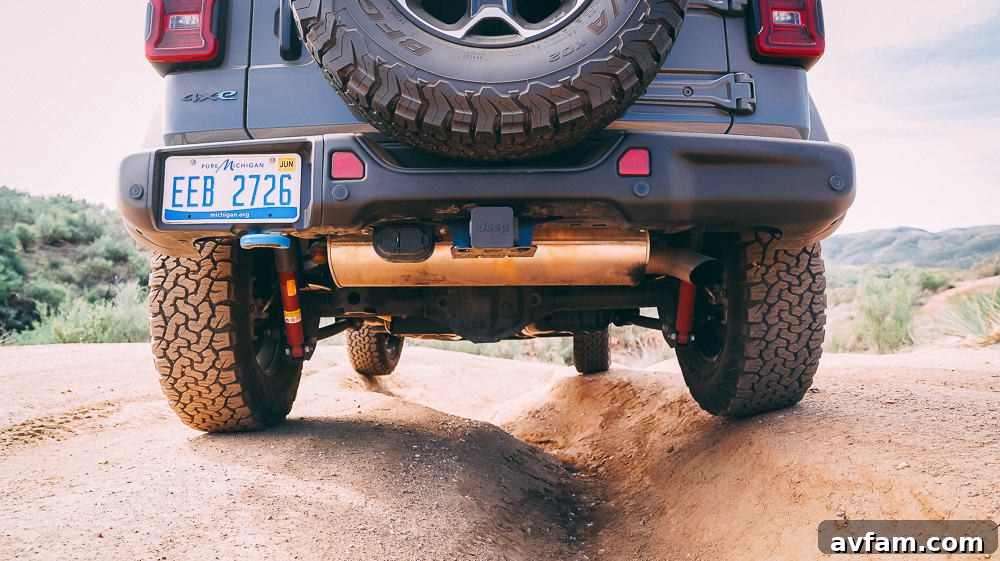 Jeep Wrangler 4XE Silent Trailblazer 4 Jeep Wrangler 4XE's rear view on an open dirt road with mountains in the background.