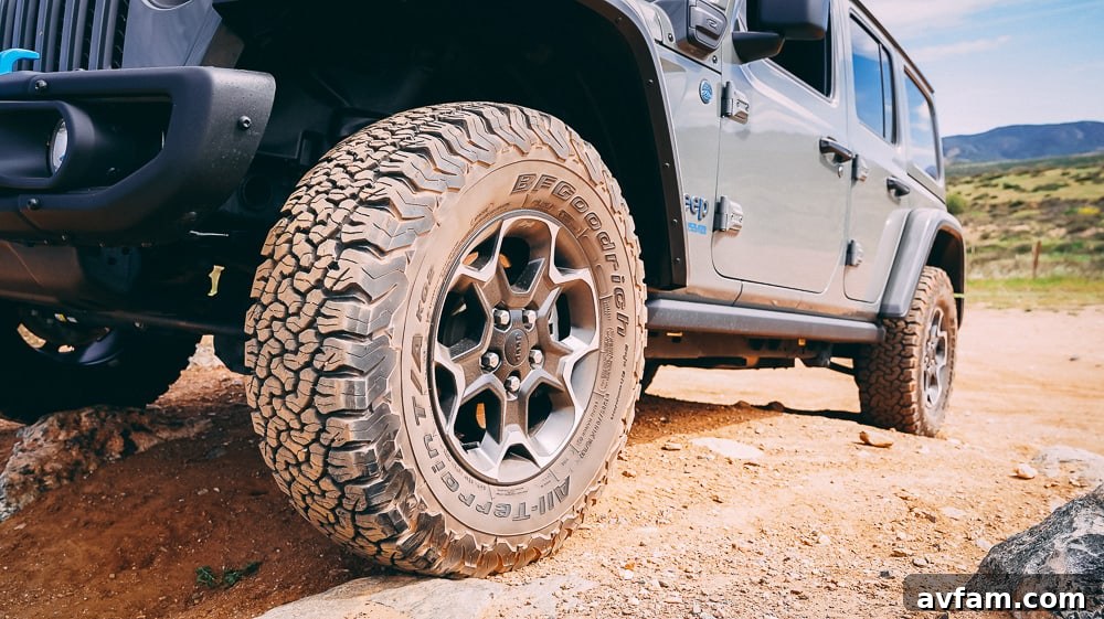 Jeep Wrangler 4XE Silent Trailblazer 9 Close-up of the Jeep Wrangler 4XE's tire and suspension as it navigates a rocky path.