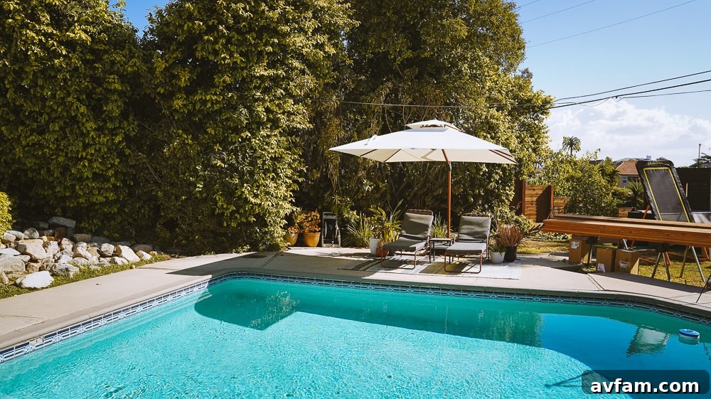 Wide shot of the backyard showing the redwood deck as a central feature near the pool