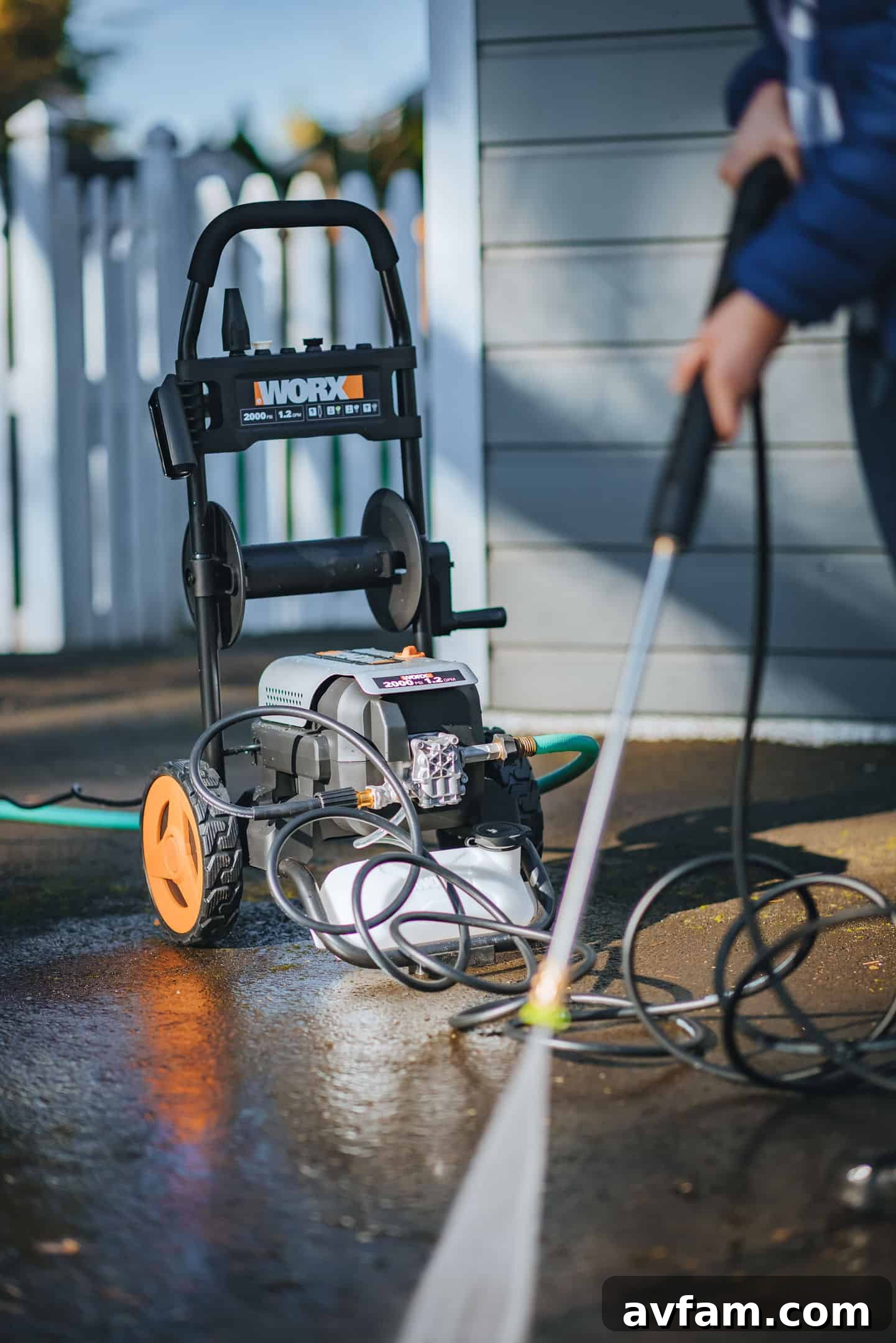 Steve Makowski using the Worx 2000 PSI pressure washer to clean a mossy wooden fence in Portland, showcasing its effectiveness.