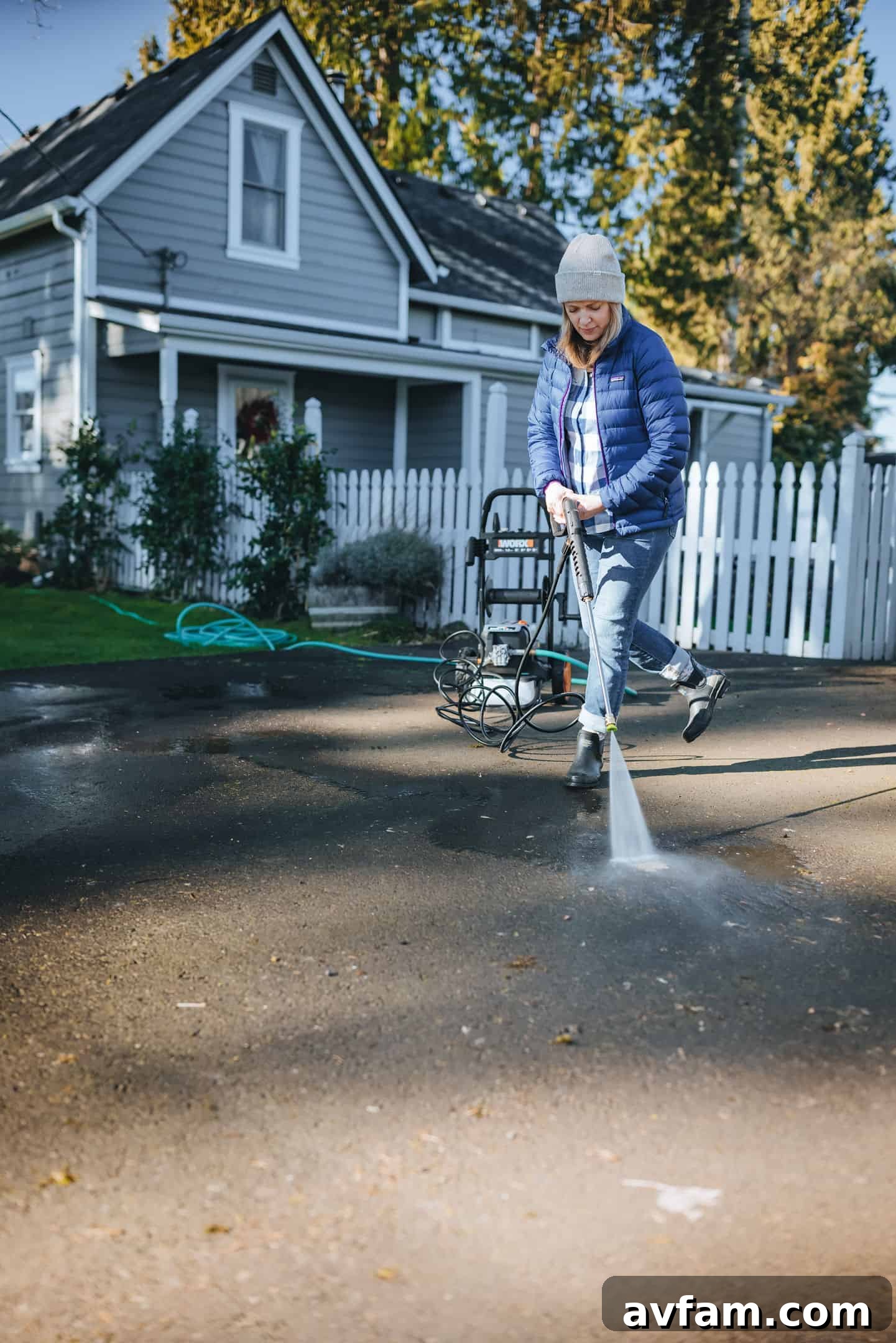 The Worx 2000 PSI pressure washer cleaning the exterior siding of a house, removing green algae and dirt.