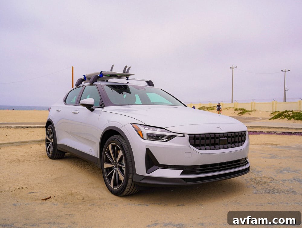 Polestar 2 driving on a scenic coastal highway, with mountains in the background