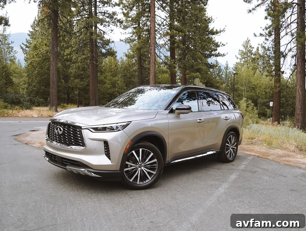 Infiniti QX60 parked by a scenic Lake Tahoe viewpoint, showcasing its sleek design.