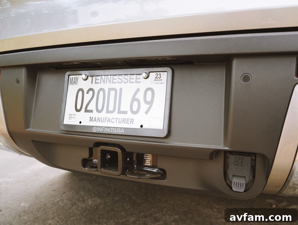 Rear view of the Infiniti QX60, emphasizing its towing hitch and sturdy build.