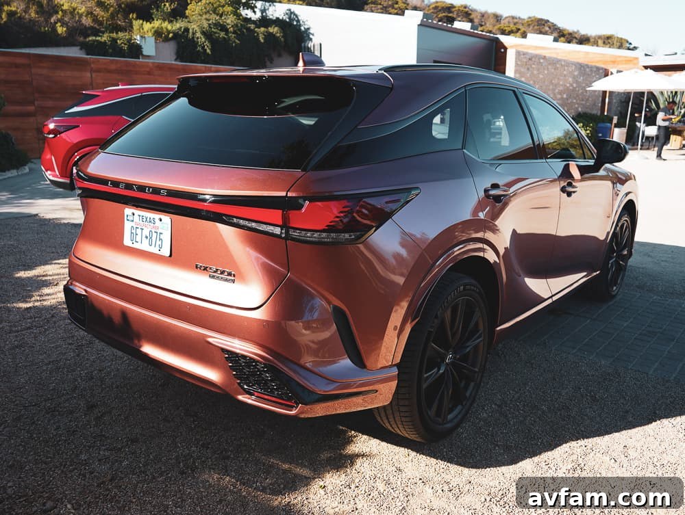 Front three-quarter view of the 2023 Lexus RX 500h F Sport Performance with a blurred background, suggesting speed.