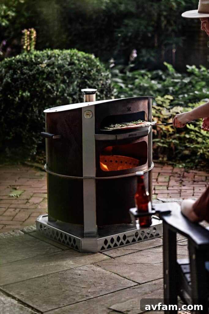 A delicious wood-fired pizza being cooked in the Breeo Live-Fire Pizza Oven, with the X24 fire pit providing the heat source.