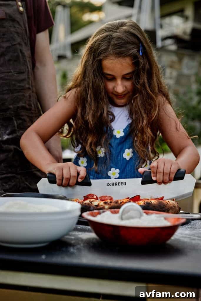 Kids excitedly preparing pizza dough on a serving board for the Breeo Live-Fire Pizza Oven.
