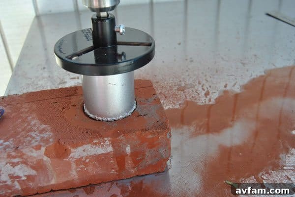 Begin drilling the brick, using water to cool and aid cutting