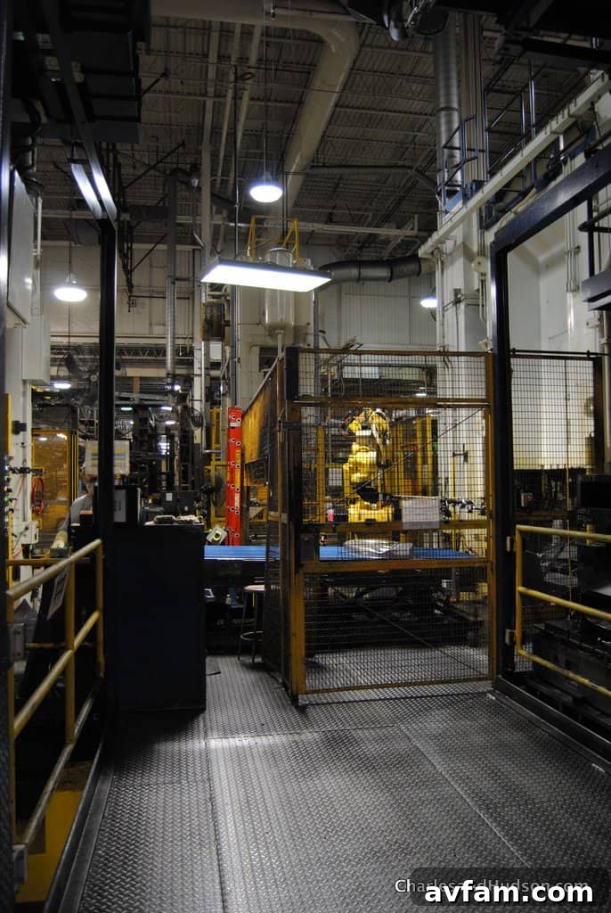 An intricate engine being carefully lowered into a John Deere chassis