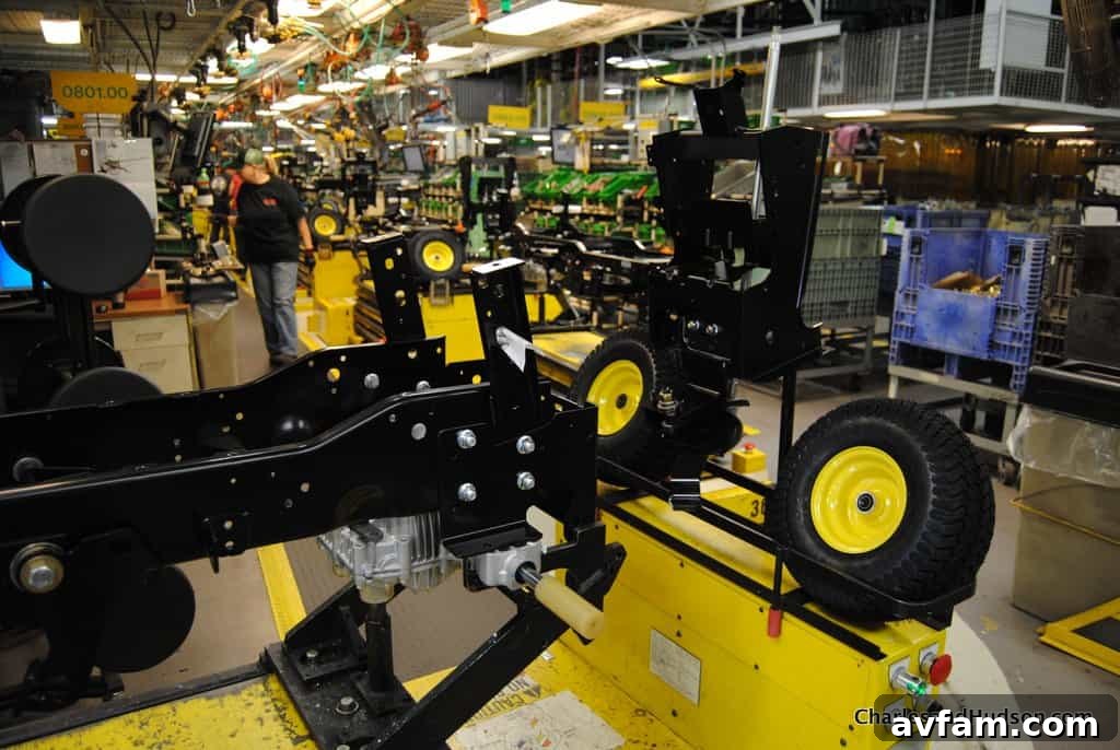 Workers inspecting the paint finish of John Deere parts before assembly