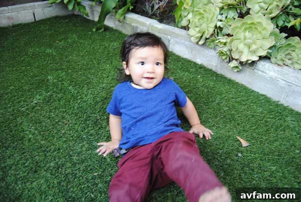 Two happy children playing safely on a lush, green SynLawn artificial grass surface, showcasing the family-friendly benefits of synthetic turf for outdoor activities