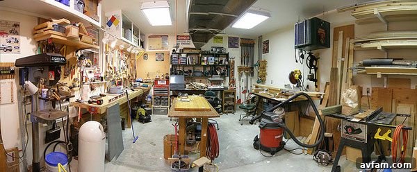 Brightly lit garage workshop with overhead LED lighting and task lamps.