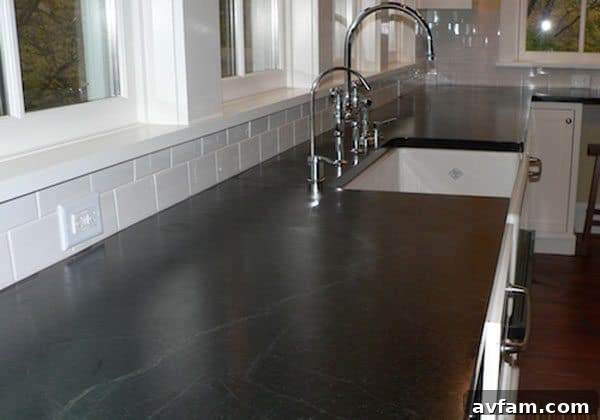 Rustic soapstone countertop showcasing its natural dark patina and soft texture in a traditional kitchen