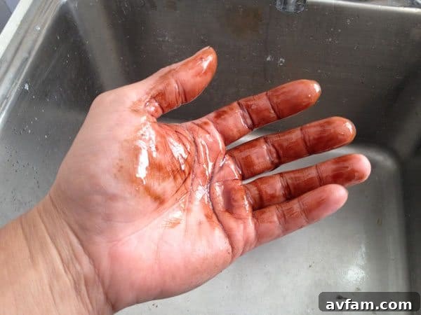 Hands heavily soiled with a sticky mixture of oil and dirt, ready for the hand cleaner test.