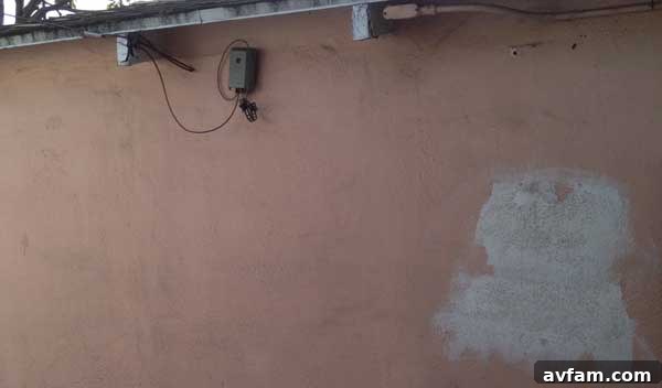 Close-up of the dirty pink garage wall with unpainted white plaster before renovation.