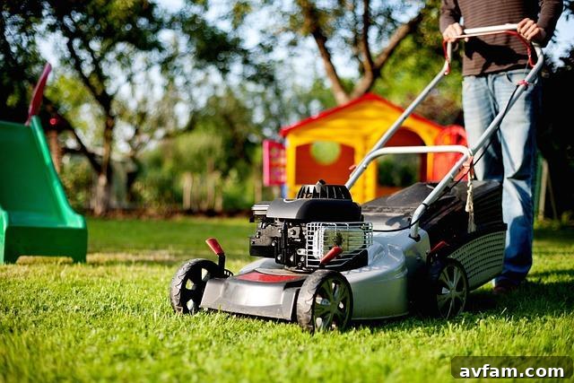 Person emptying a full lawn sweeper hopper onto a large compost pile