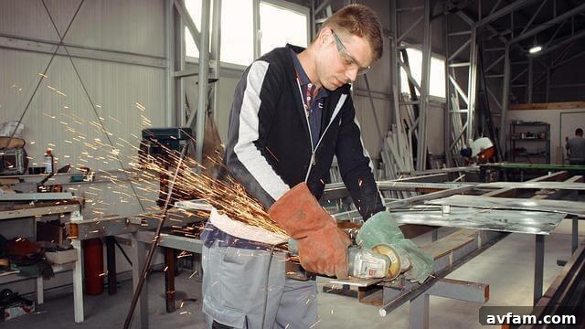 Man operating a grinder power tool to shape metal