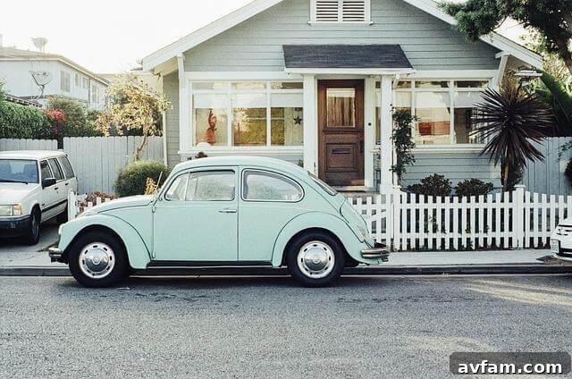 Small blue car parked in front of a house