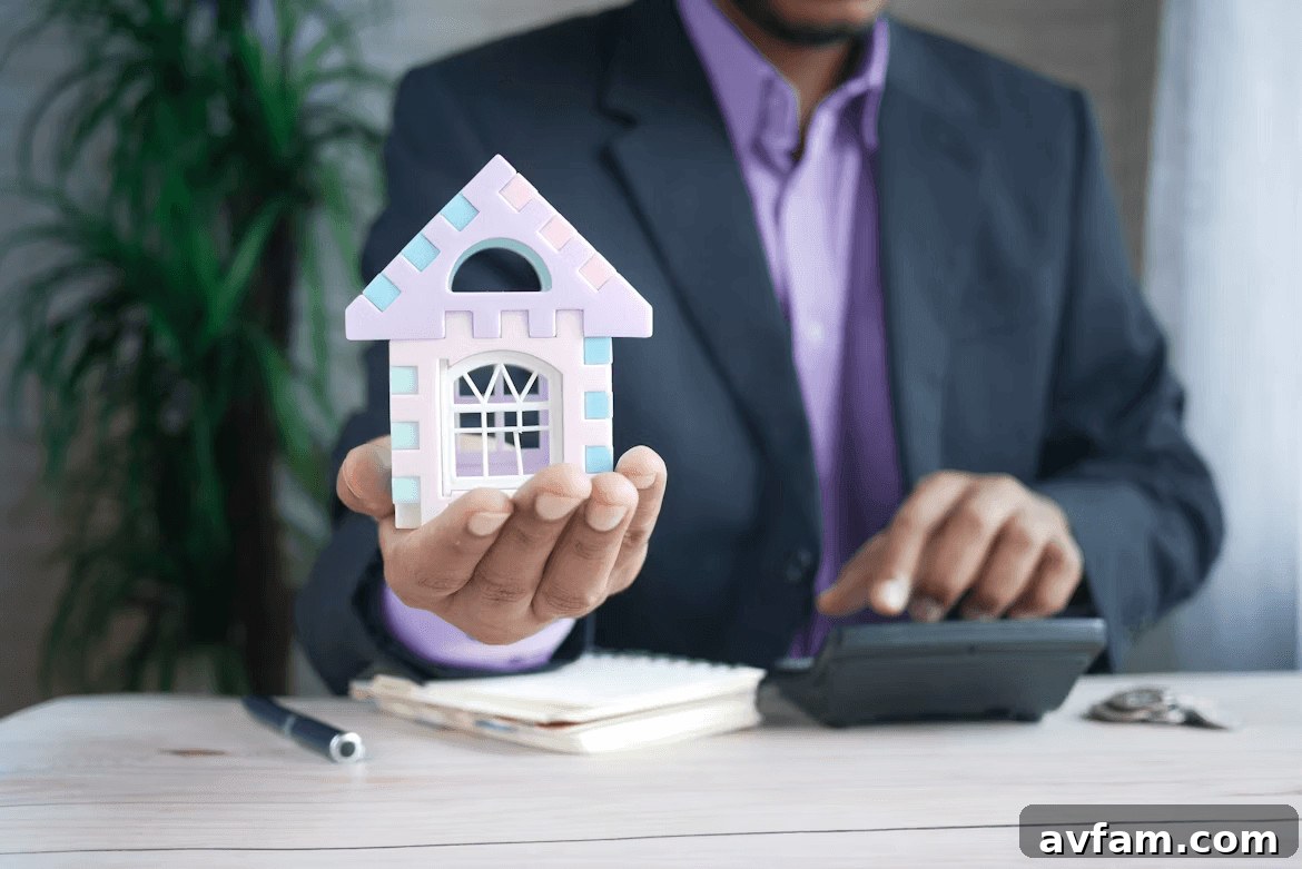 Man in suit holding toy house, symbolizing first