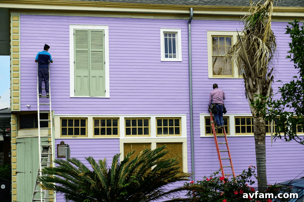 Two men painting a purple house