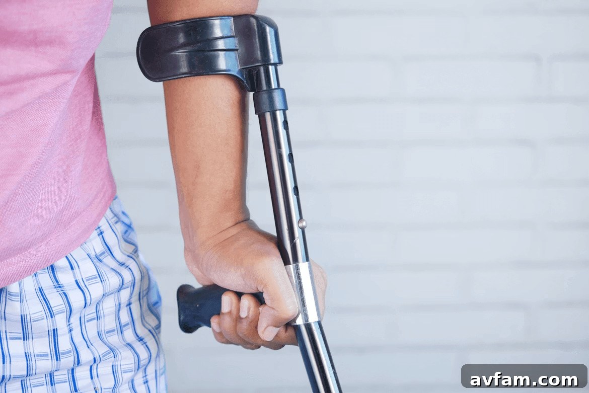 Person holding a crutch and walking cane after
