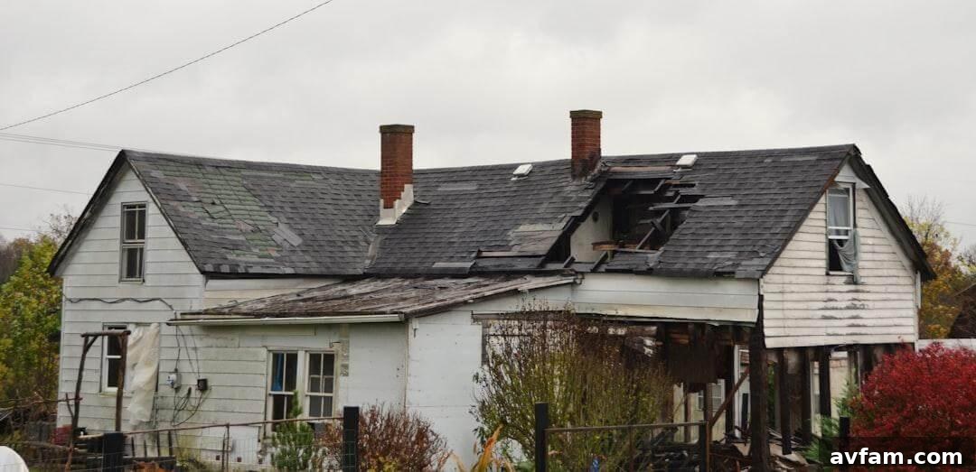 A weathered older house with worn siding and an aging roof in need of repairs