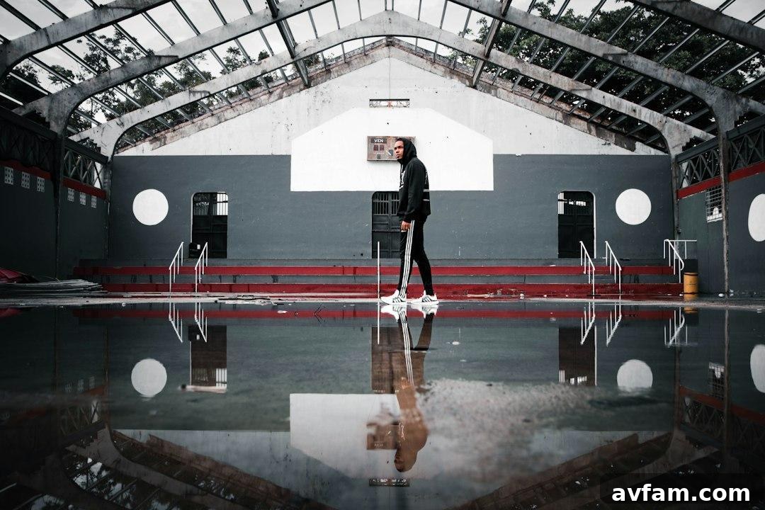 A person operating a walk-behind floor scrubber in a large room